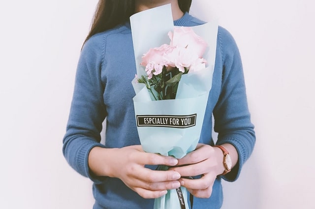 Registry Rewards: A New Perk Created Just For You, A girl holding a small bouquet of pink flowers in a bouquet cover that says 'especially for you.'